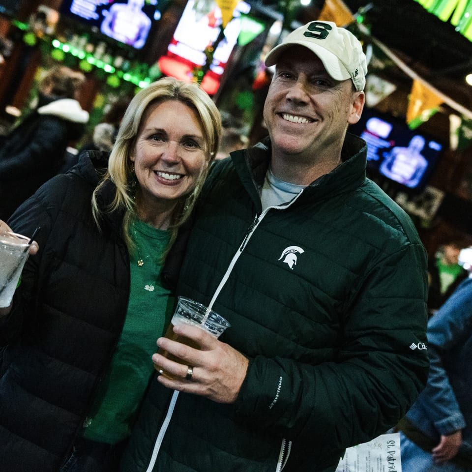 Smiling couple holding drinks inside the tavern